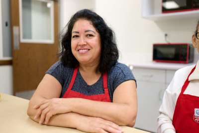 Alejandra, a DI associate, sits at a table with other coworkers during a work meeting at DI