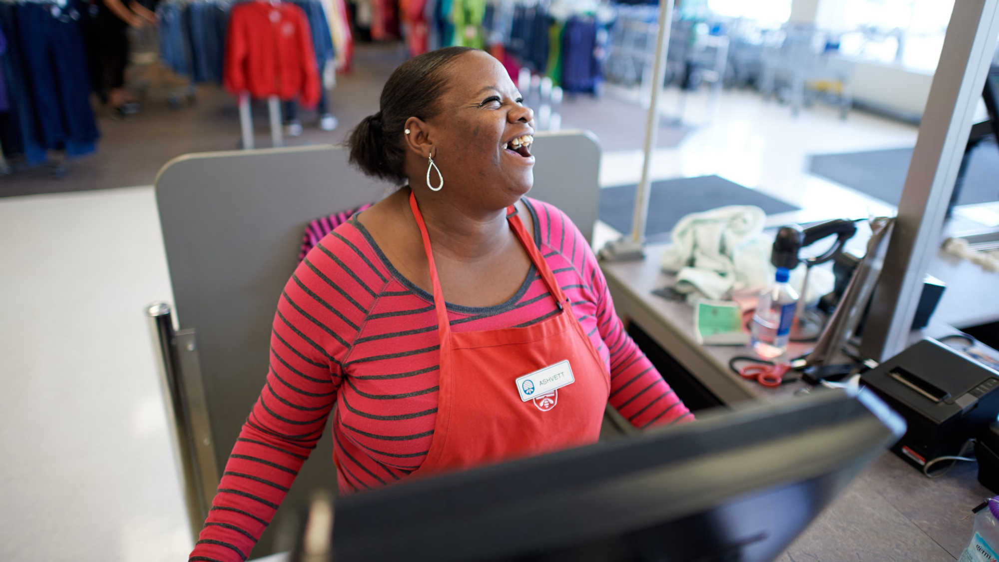 Female associate laughing and smiling at the cash register